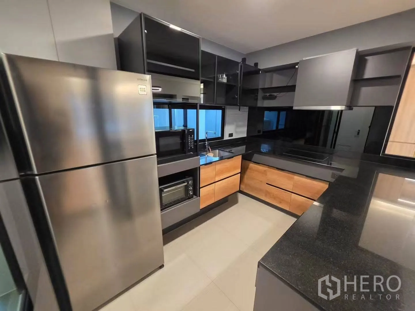ทาวน์เฮาส์ for rent in Bang Phli, Samut Prakan - ครัวรูปตัว U ท็อปหินสีเข้ม ตู้ลายไม้ และเครื่องใช้สแตนเลส