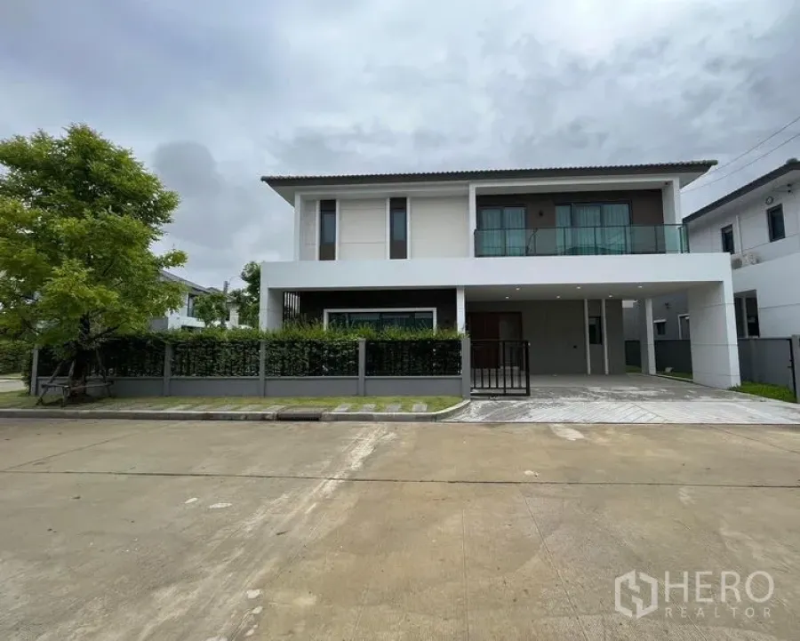 Detached House for rent in Don Mueang, Bangkok - Street-facing view of the Don Mueang house with fenced front garden and covered parking.
