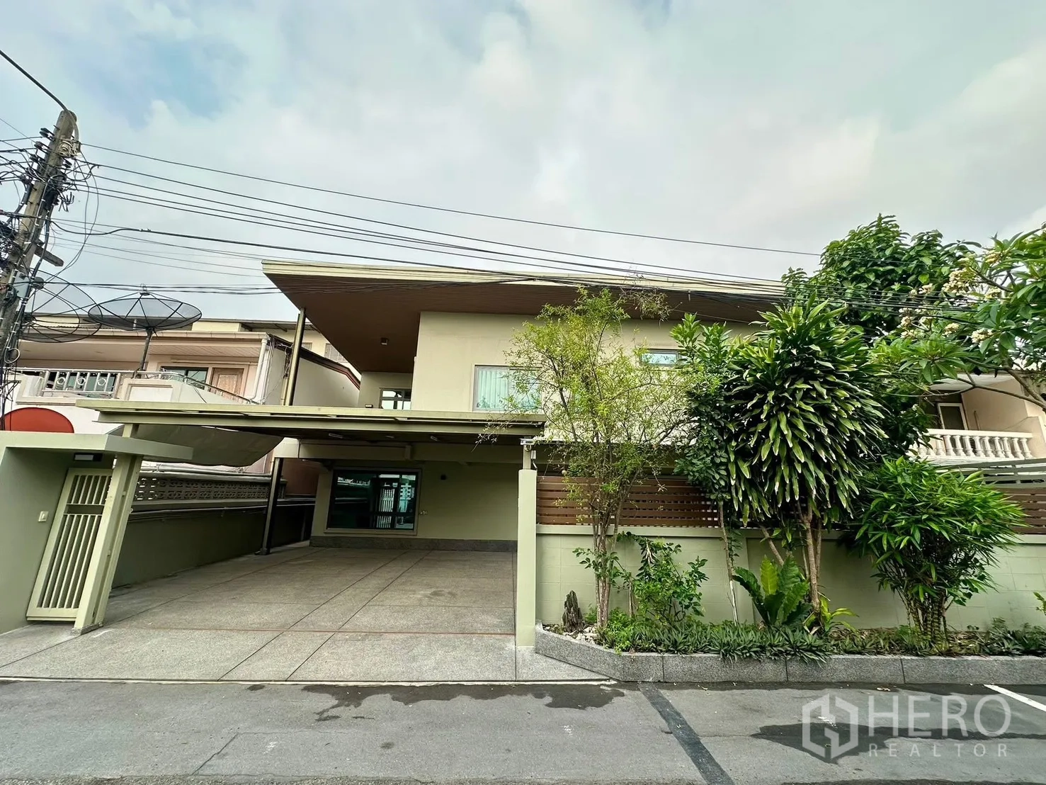 บ้าน for rent in Watthana, Bangkok - มุมมองหน้าบ้านเดี่ยวจากถนน พร้อมทางรถเข้าและสวนสวย