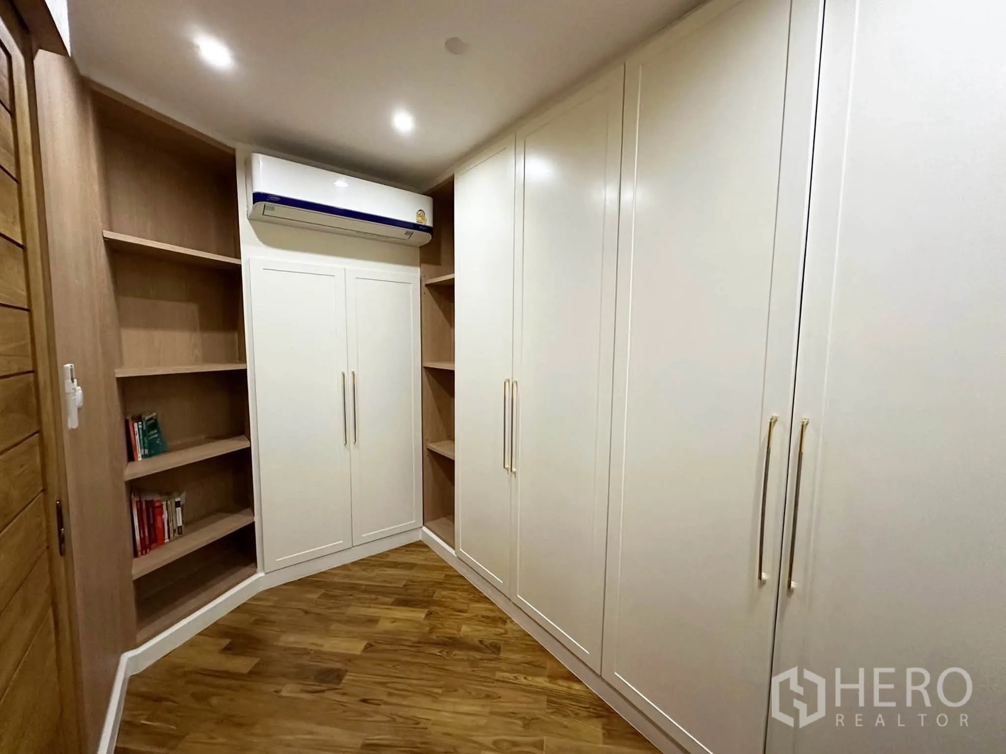 Condominium for sale in Khlong San, Bangkok - Built-in wardrobes and corner shelving in a storage room with wood floors.