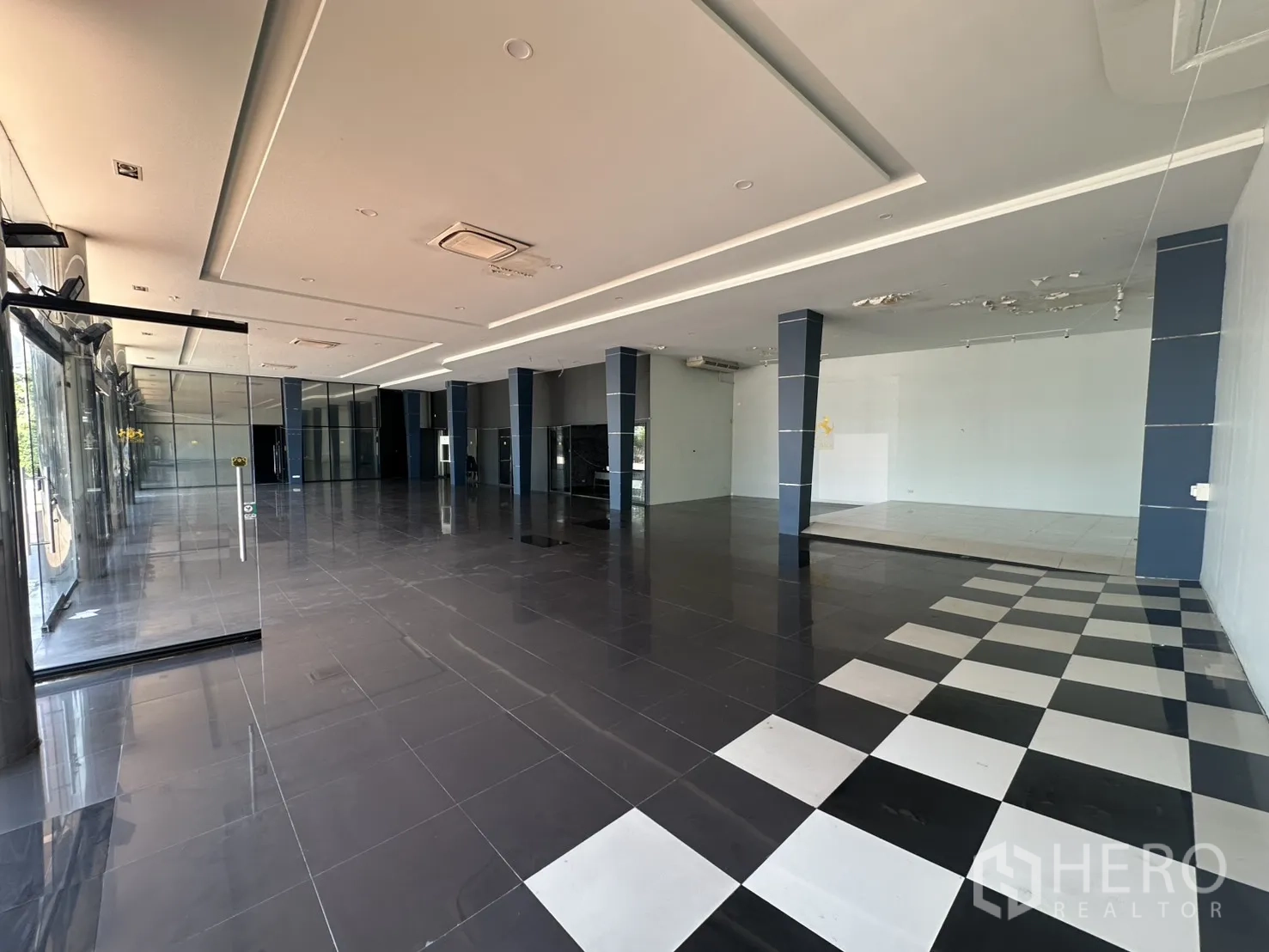 展厅 for rent in Suan Luang, Bangkok - 宽阔展厅全景，棋盘格地砖与展示台一览。