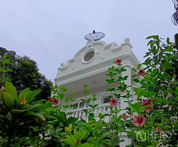 联排别墅 出售在Khlong Toei, Bangkok - 从花园仰望装饰性山墙与阳台，屋顶设有卫星天线。