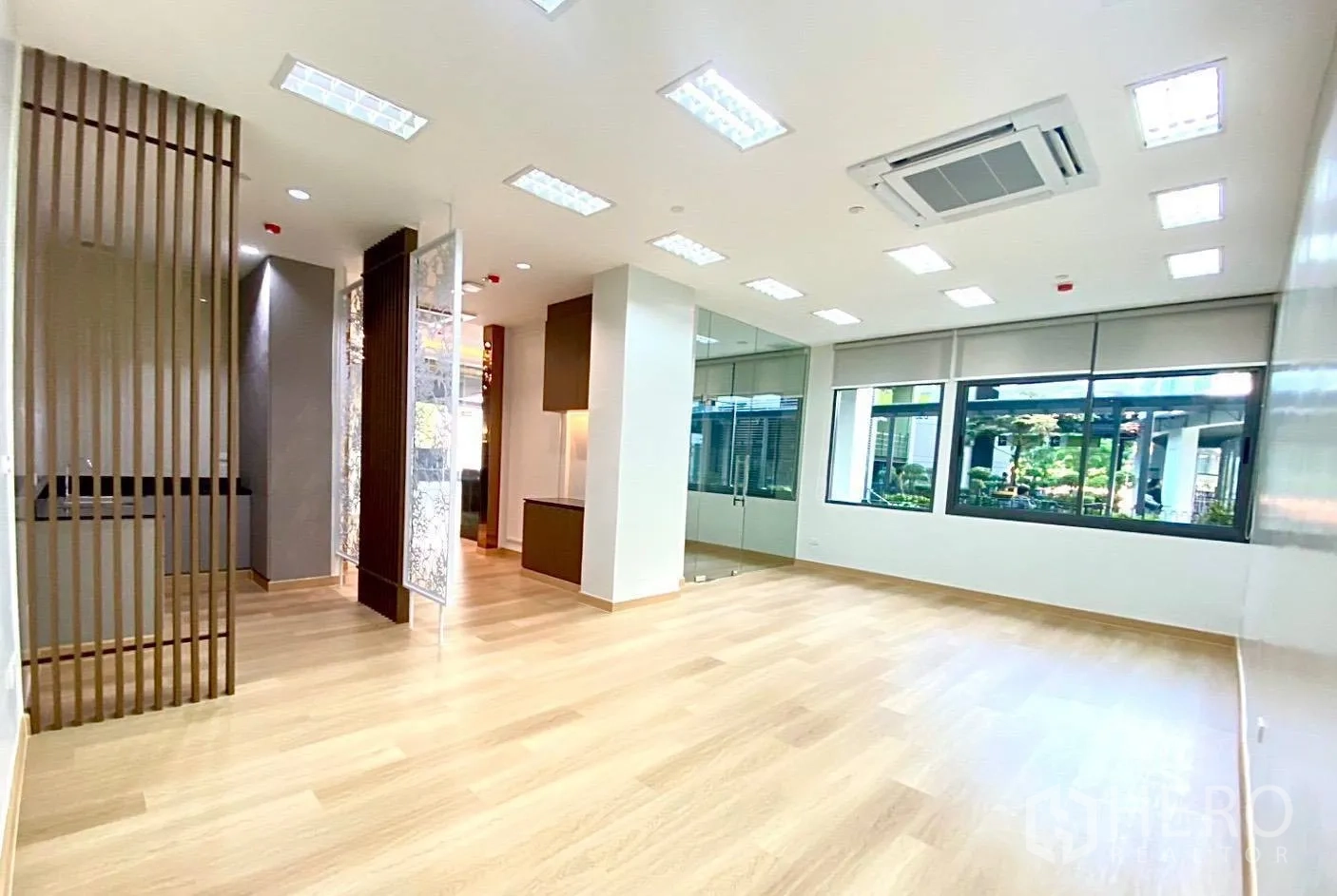 Office Space for rent - Open-plan office floor with large windows, LED ceiling lights and light wood flooring.