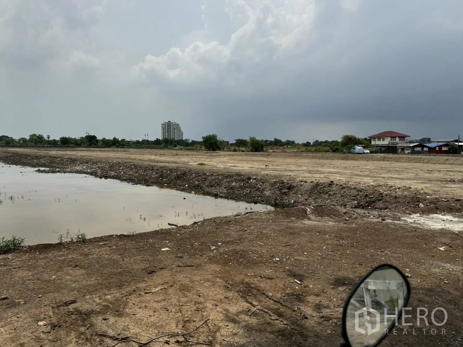 Land for sale in Bang Phli, Samut Prakan - Water channel and earthen embankment along the edge of the land with nearby houses.