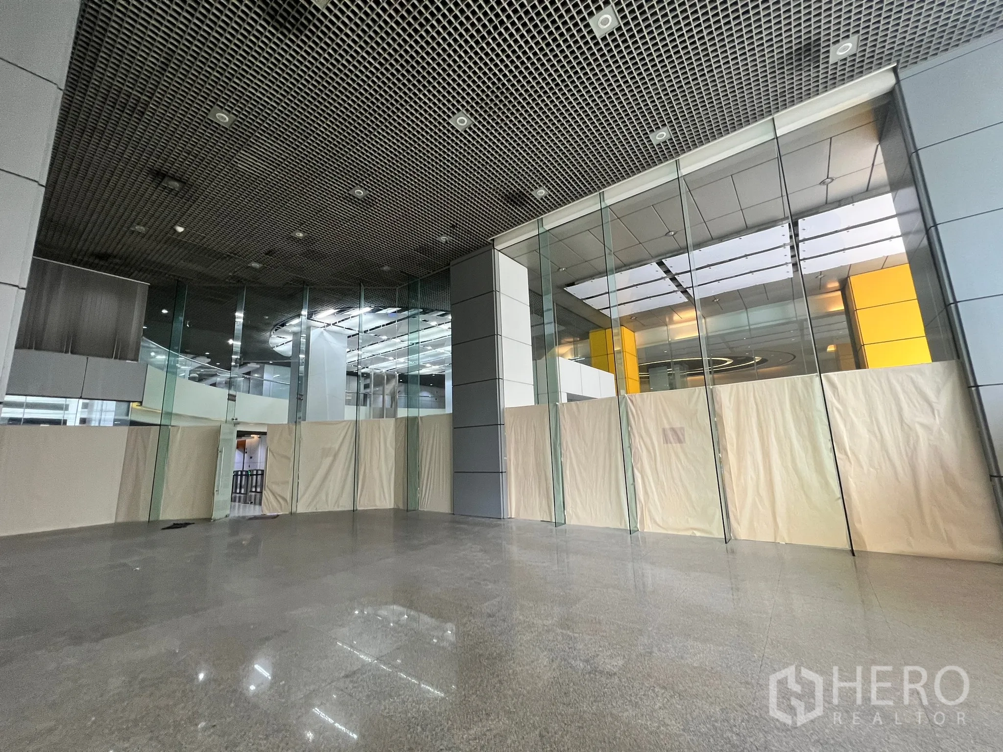 พื้นที่ขายปลีก ให้เช่าในWatthana, Bangkok - พื้นที่ค้าปลีกแบบเปิดโล่ง ผนังกระจกขนาดใหญ่และเพดานกริด ภายในโถงอาคารเชิงพาณิชย์.