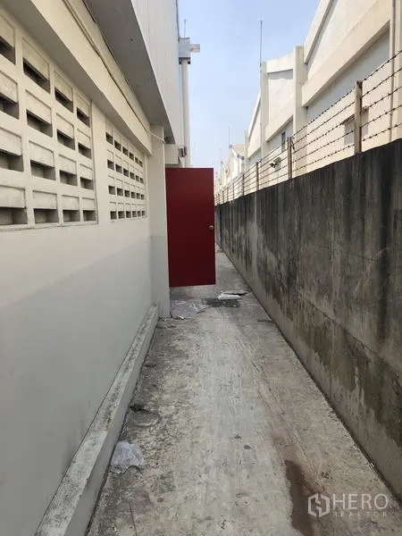 โรงงาน ให้เช่าในKhlong Luang, Pathum Thani - ทางเดินบริการด้านหลัง ประตูหนีไฟสีแดง กำแพงรักษาความปลอดภัย