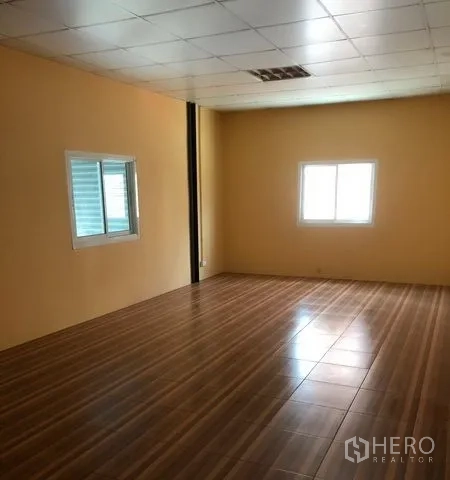 Warehouse for rent in Pak Kret, Nonthaburi - Large upstairs office with wood-look flooring and windows for natural light.