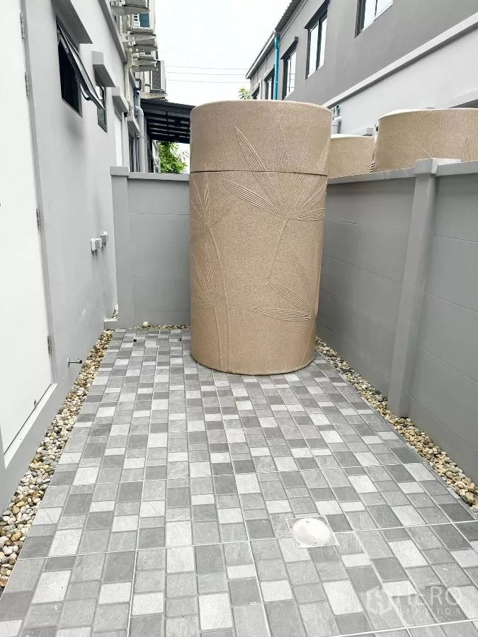 Townhouse for rent in Bang Phli, Samut Prakan - Rear service yard with tiled floor and large water storage tank.