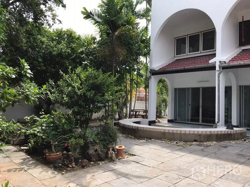 บ้าน ให้เช่าในPhra Khanong, Bangkok - มุมด้านหลังบ้านมีระเบียงโค้ง ประตูกระจกบานเลื่อน และสวนจัดแต่ง