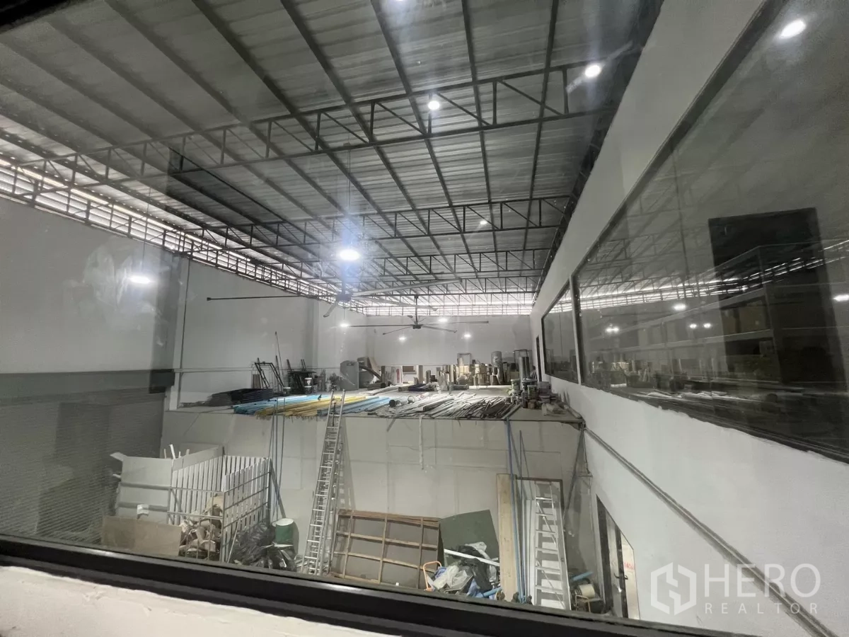 คลังสินค้า ให้เช่าหรือขายในLat Krabang, Bangkok - มุมมองผ่านกระจก เห็นพื้นโกดัง โครงหลังคา และอุปกรณ์