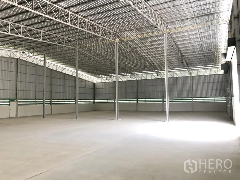Warehouse for rent in Lat Lum Kaeo, Pathum Thani - Spacious warehouse interior with high steel truss roof and smooth concrete floor.