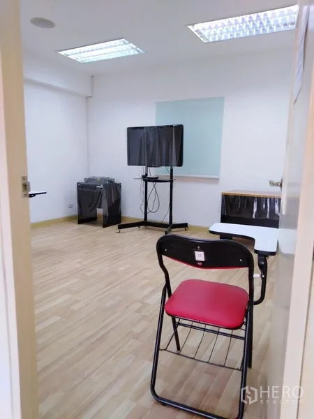 Office Space for sale in Bang Kapi, Bangkok - Training or meeting room with a TV on a stand, desks and bright overhead lights.
