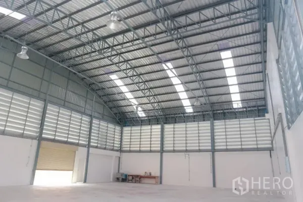 Factory for sale in Bang Pakong, Chachoengsao - Spacious warehouse interior with high arched steel roof, skylights, and louvered ventilation.