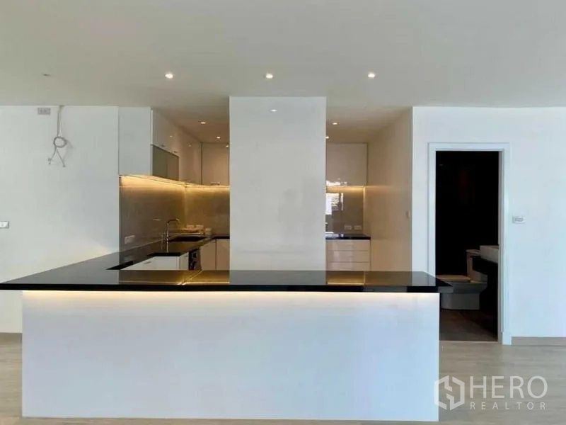 คอนโด ให้เช่าในBang Rak, Bangkok - เพนนินซูลาเคาน์เตอร์ครัวท๊อปสีดำ ไฟแอลอีดี และประตูสู่ห้องอเนกประสงค์