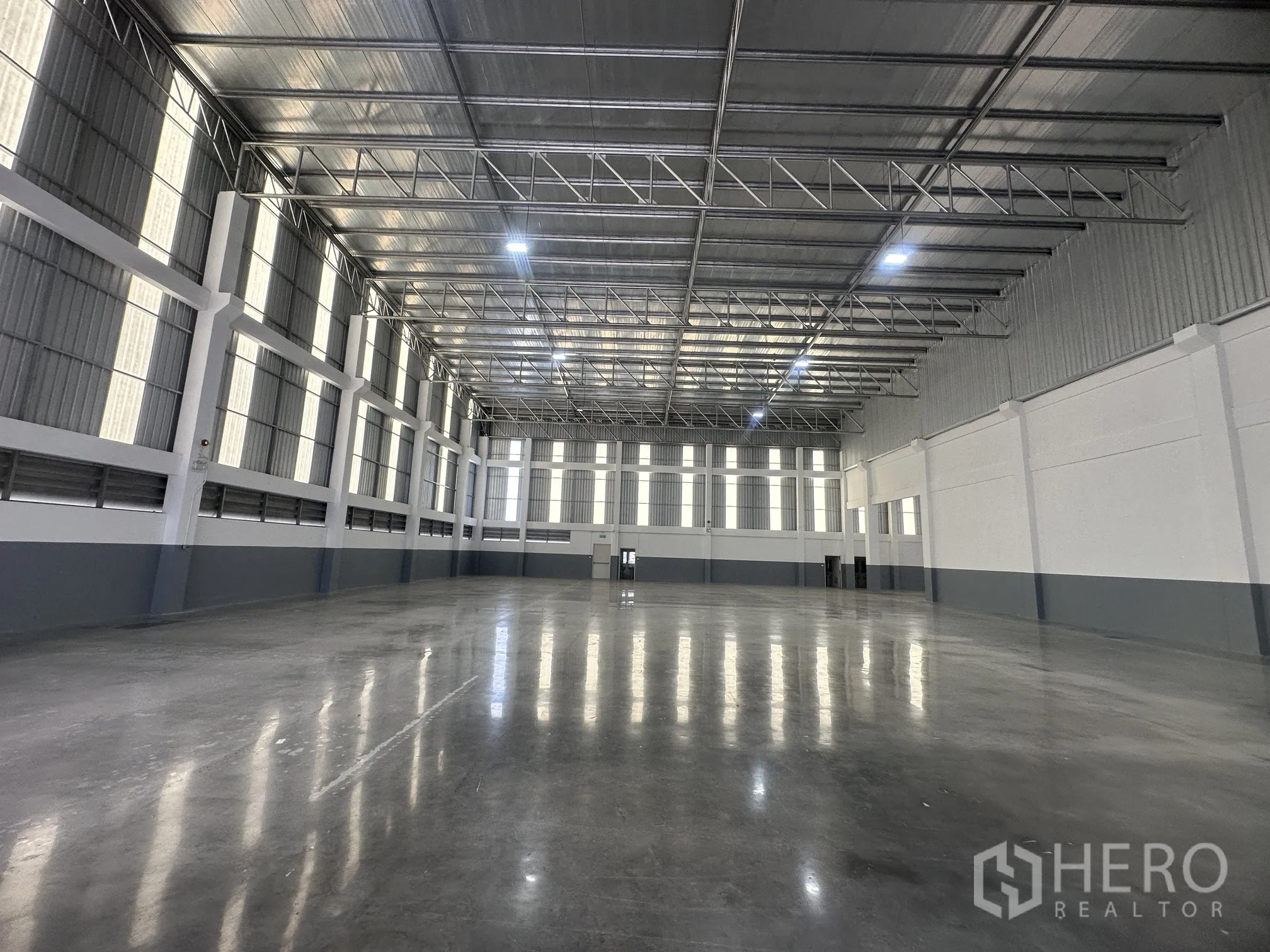 Factory for rent in Bang Phli, Samut Prakan - High-bay production area with rows of windows and grey-and-white walls.