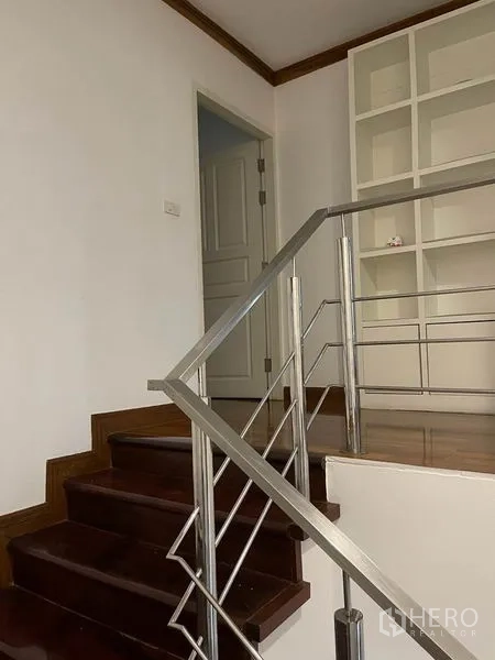公寓 出租在Pathum Wan, Bangkok - 室内楼梯配不锈钢扶手，通往带置物架的楼梯平台。