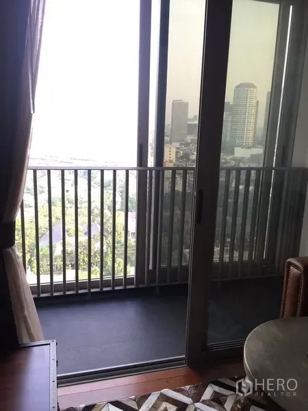 Condominium for rent in Khlong Toei, Bangkok - Private balcony with sliding glass doors offering a city skyline view.