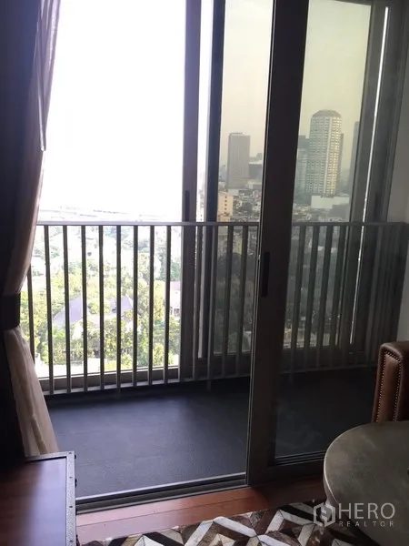 Condominium for rent in Khlong Toei, Bangkok - Private balcony with sliding glass doors offering a city skyline view.