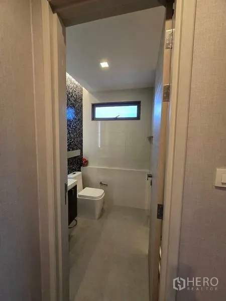Condominium for rent - Modern bathroom with a window, vanity and toilet finished in neutral tiles.