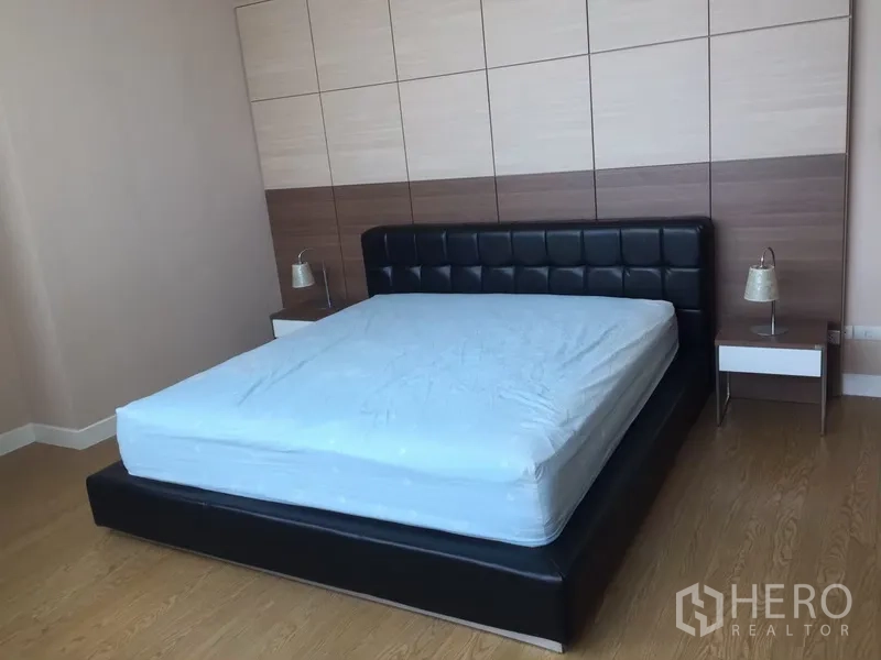 คอนโด ให้เช่าในKhlong Toei, Bangkok - ห้องนอนใหญ่ เตียงหนังหัวเตียงบุ ผนังตกแต่ง และโต๊ะหัวเตียง