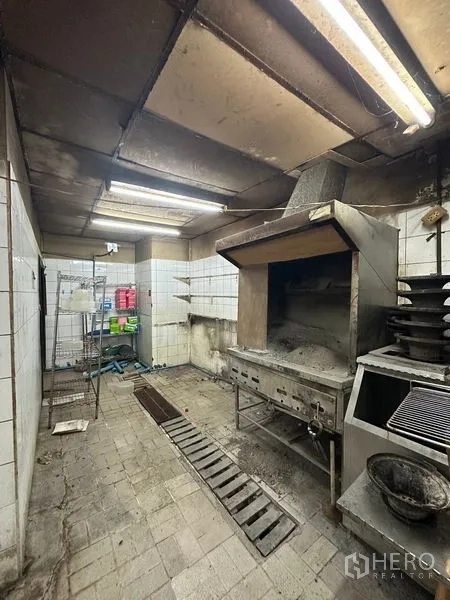 零售空间 出租在Yan Nawa, Bangkok - 商用厨房带排烟罩与烤炉，瓷砖墙面，需翻新。