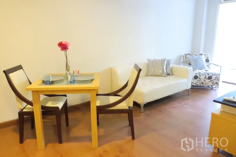 คอนโด ขายในPhra Khanong, Bangkok - พื้นที่นั่งเล่นและทานอาหารสว่าง พื้นไม้ โต๊ะอาหารสองที่นั่ง โซฟาและเก้าอี้อาร์มแชร์สีครีม