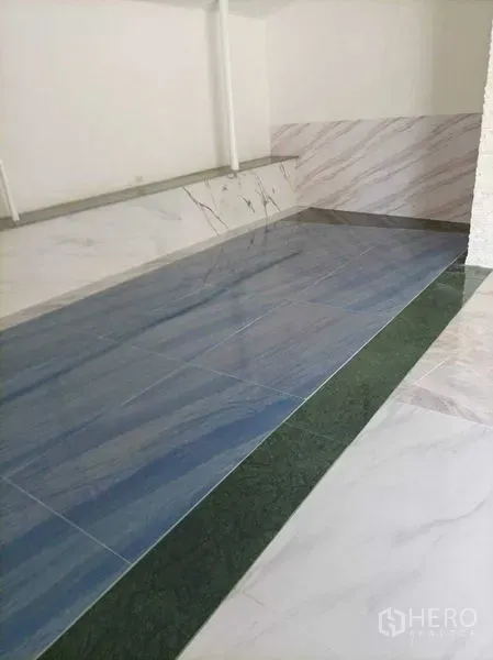 พื้นที่ขายปลีก ให้เช่าในPrawet, Bangkok - โซนโชว์รูมภายใน ปูกระเบื้องลายหินอ่อนโทนสีน้ำเงิน‑เขียว ผนังสีขาว