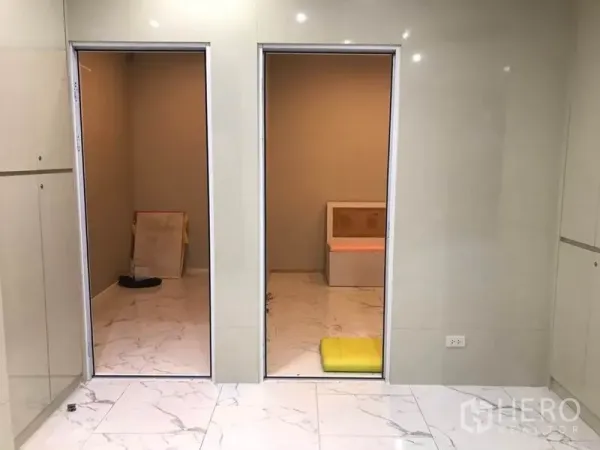 零售空间 出租在Watthana, Bangkok - 主营业区连通两间小房，亮面地砖与中性色墙面。