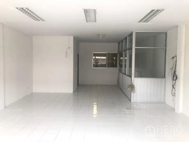 工厂 出租在Khlong Luang, Pathum Thani - 明亮的瓷砖办公区，带玻璃隔断会议室。