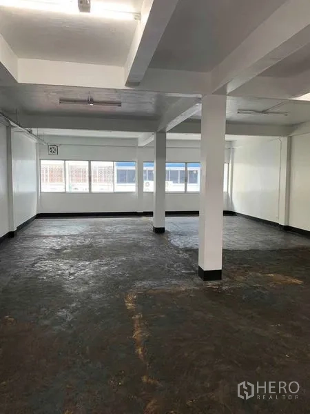 Office Space for rent in Bang Rak, Bangkok - Open-plan office floor with white walls, support columns and long windows providing natural light.