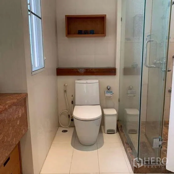 独立式住宅 出租在Lat Krabang, Bangkok - 紧凑卫浴区，带窗户、坐便器与玻璃淋浴间。