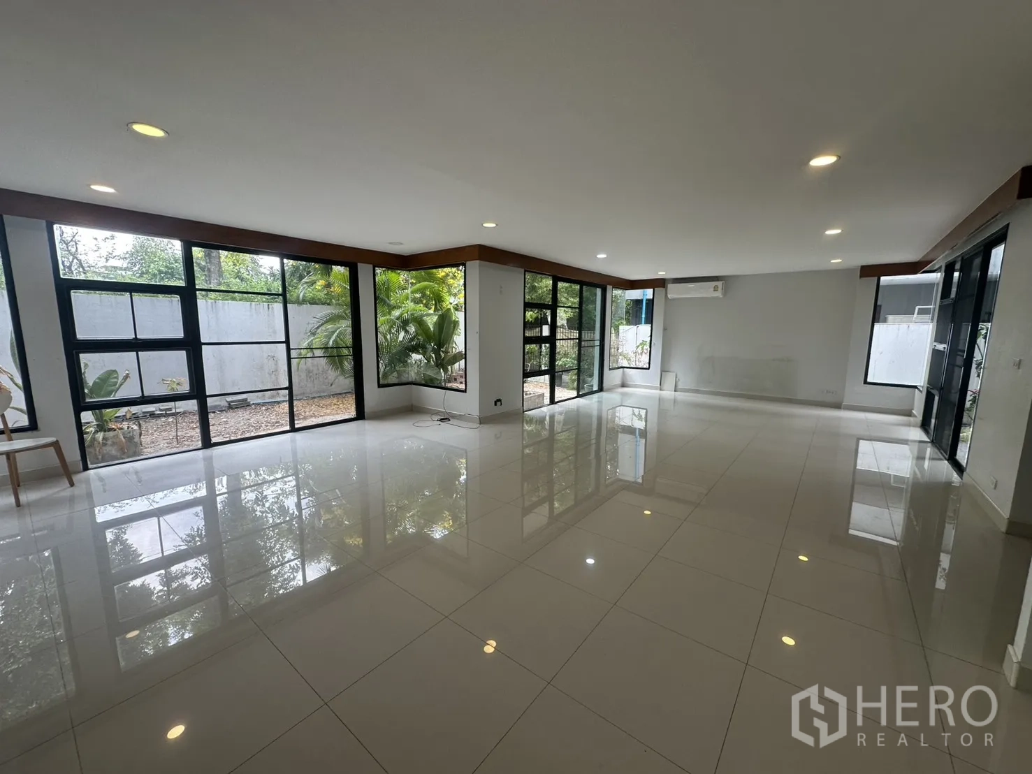 独栋房屋 for rent in Watthana, Bangkok - 超大客厅，亮面地砖与转角落地窗，面向小花园