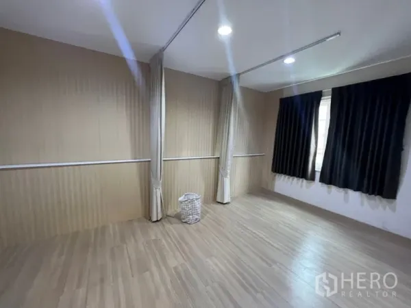 带办公室的家 出租 - 多功能房，木质墙面，带帘轨可分隔空间，窗户配深色窗帘。