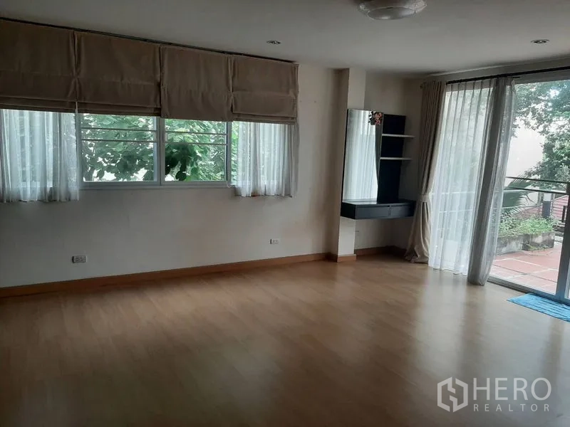 Home Office for sale in Phra Khanong, Bangkok - Bright bedroom or studio with balcony access, vanity corner and floor-to-ceiling glass.