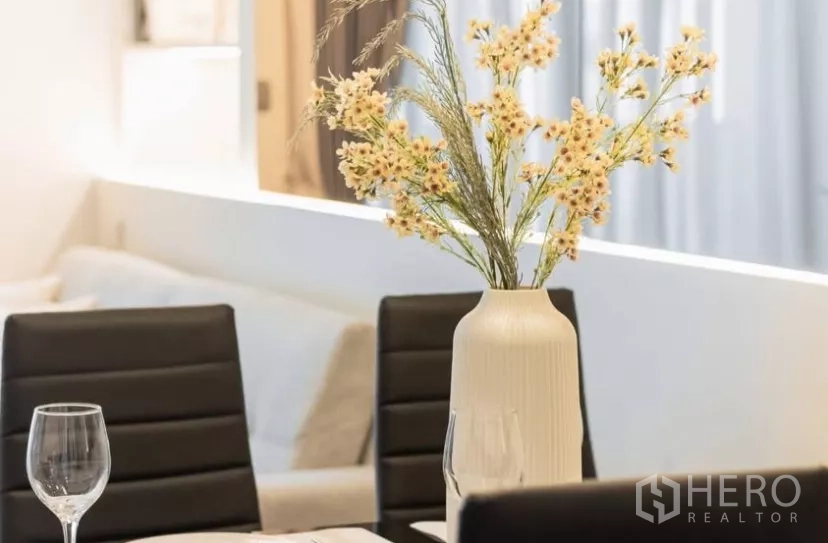 Condominium for rent in Chatuchak, Bangkok - Styled dining table centerpiece with vase and wine glasses on leather chairs.