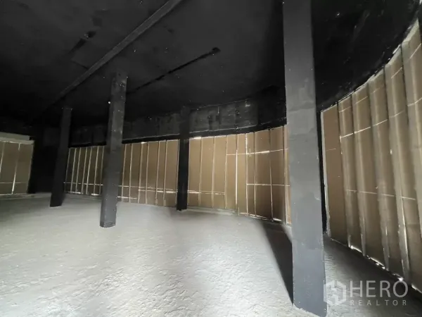 พื้นที่ขายปลีก ให้เช่า - พื้นที่ค้าปลีกชั้นล่าง ห้องเปล่า หน้าร้านโค้ง เพดานสีดำ พื้นคอนกรีตและเสารับน้ำหนัก