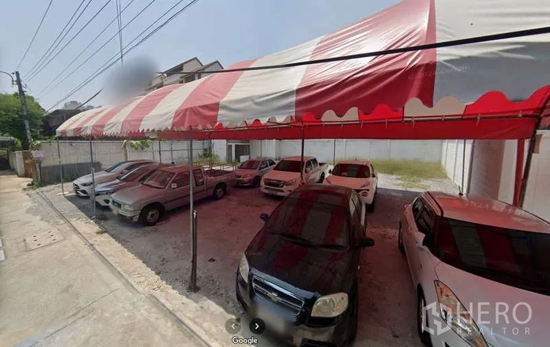 Land for rent in Sathon, Bangkok - Level land used as a shaded parking area with a red-and-white canopy and multiple cars in Sathon.