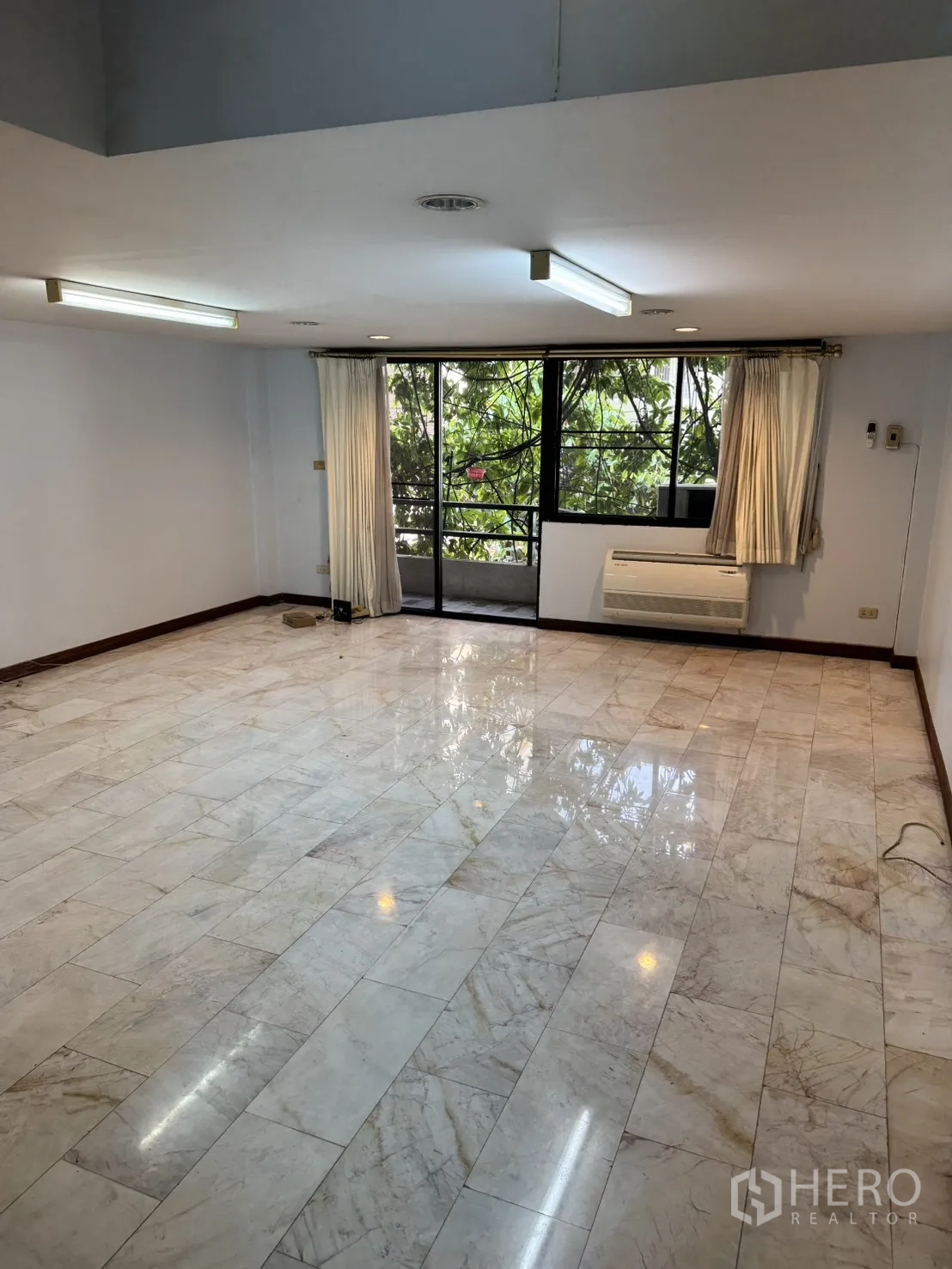 โฮมออฟฟิศ for rent in Watthana, Bangkok - ห้องขนาดใหญ่ปูพื้นหินอ่อน หน้าต่างกว้าง มองเห็นต้นไม้ระเบียง