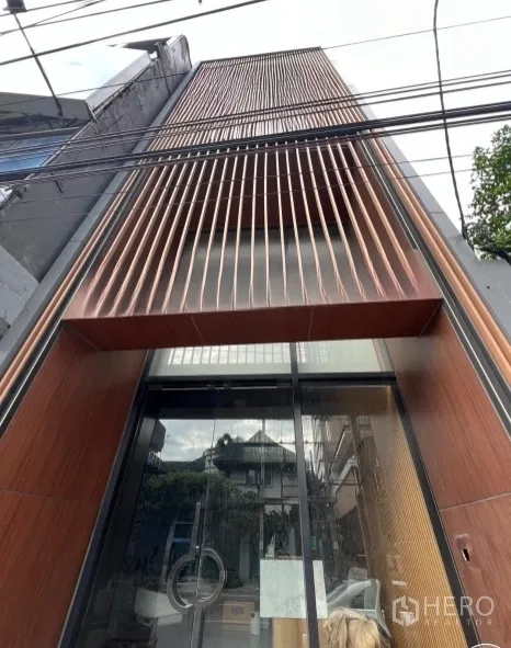 อาคารพาณิชย์ ให้เช่าในWatthana, Bangkok - ด้านหน้าตึกอาคารพาณิชย์สมัยใหม่ ซี่ไม้แนวตั้งและประตูกระจกเต็มบาน ในย่านเอกมัย กรุงเทพฯ