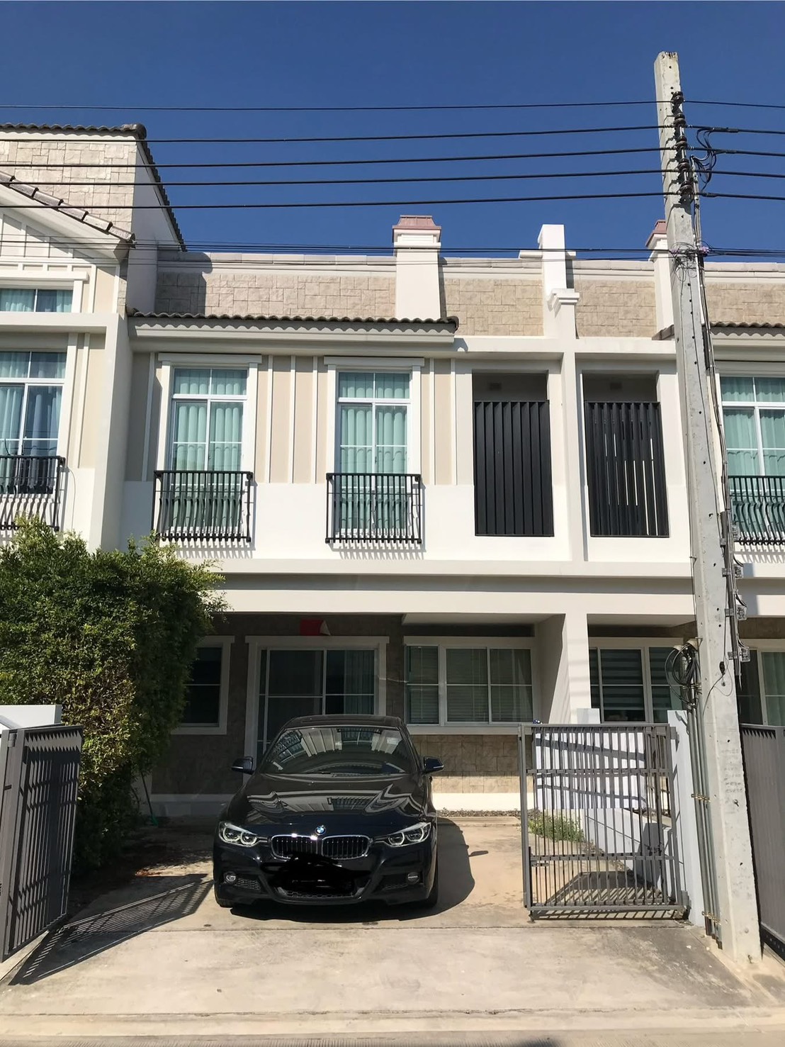 联排别墅 for rent in Prawet, Bangkok - 两层联排别墅外立面，带栅栏车道与小阳台。