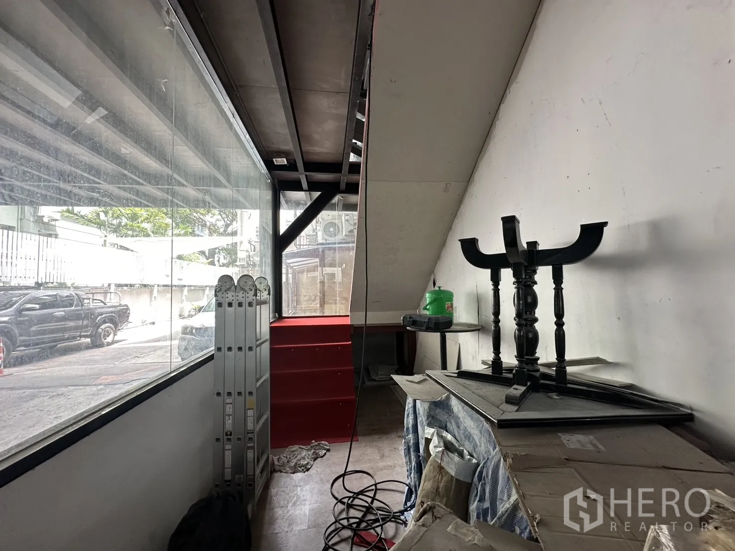 Retail Space for rent in Watthana, Bangkok - Narrow showroom space with floor-to-ceiling window and red steps leading upward.