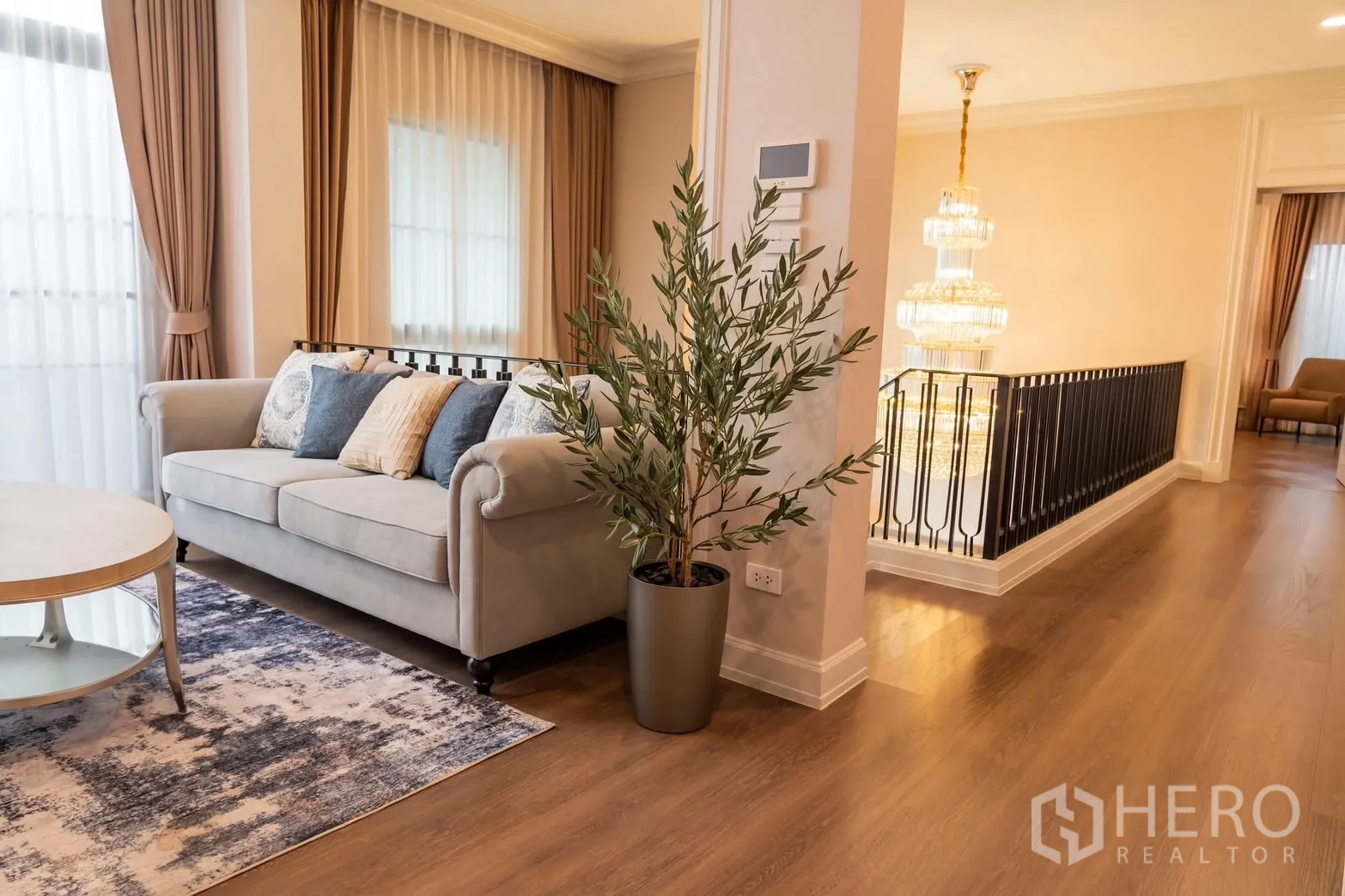 Detached House for rent in Saphan Sung, Bangkok - Corridor beside chandelier with potted plant and wood flooring.