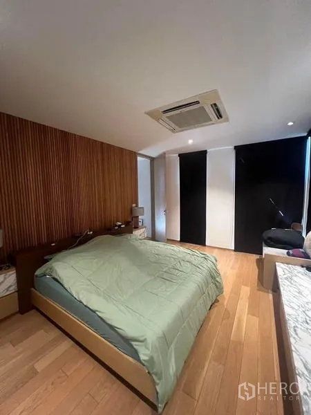 Townhouse for rent - Master bedroom with wood slat accent wall, large bed and blackout blinds