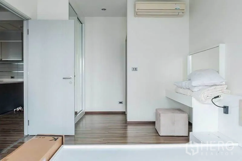 คอนโด ให้เช่าในKhlong Toei, Bangkok - ห้องนอนพื้นไม้ เตียงยกระดับ แอร์แขวนผนัง และทางเชื่อมครัว