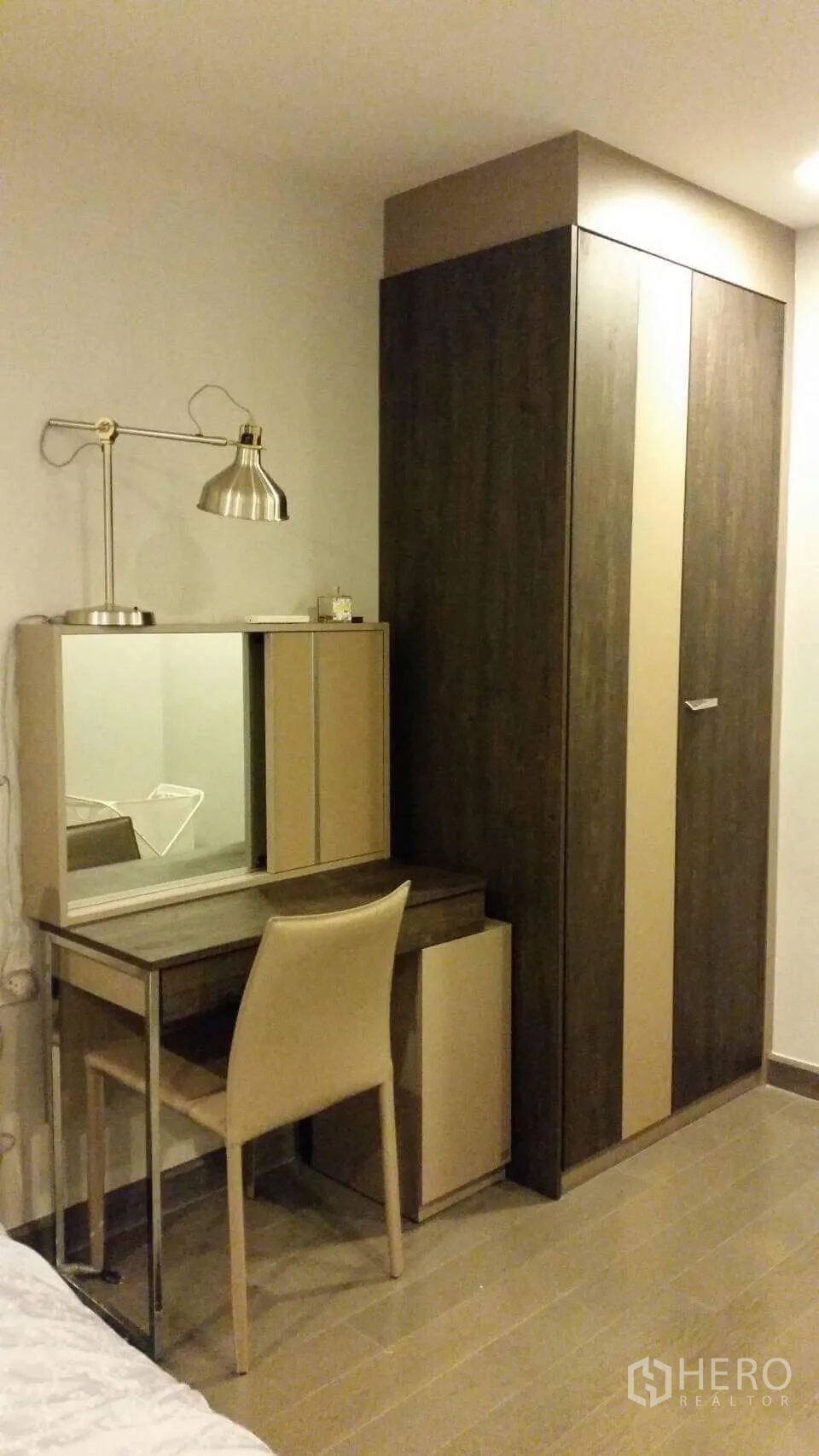 คอนโด ให้เช่าในWatthana, Bangkok - มุมห้องนอนพร้อมตู้เสื้อผ้าไม้ โต๊ะเครื่องแป้งกระจก และโคมไฟ พื้นลายไม้โทนอุ่น