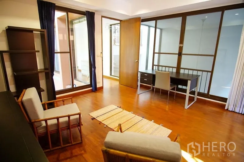 Townhouse for rent in Watthana, Bangkok - Flexible bedroom or study with desk, seating, and glass partitions.