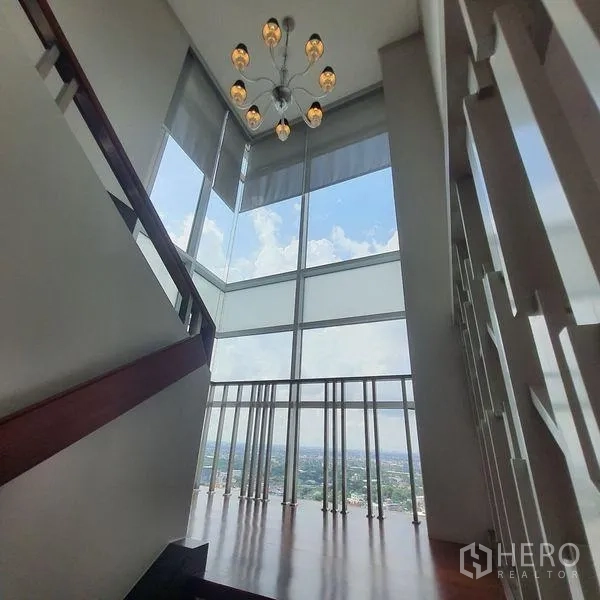 คอนโด ให้เช่าในBang Kapi, Bangkok - ชานบันไดเพดานสูงมุมกระจก พร้อมโคมไฟระย้าและวิวเมือง