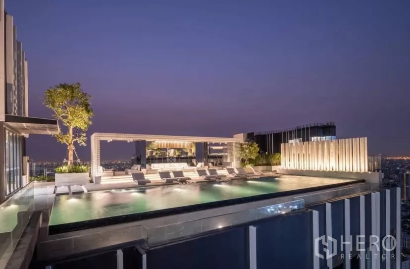 Condominium for rent in Chatuchak, Bangkok - Rooftop infinity pool at dusk with sun loungers and skyline views.