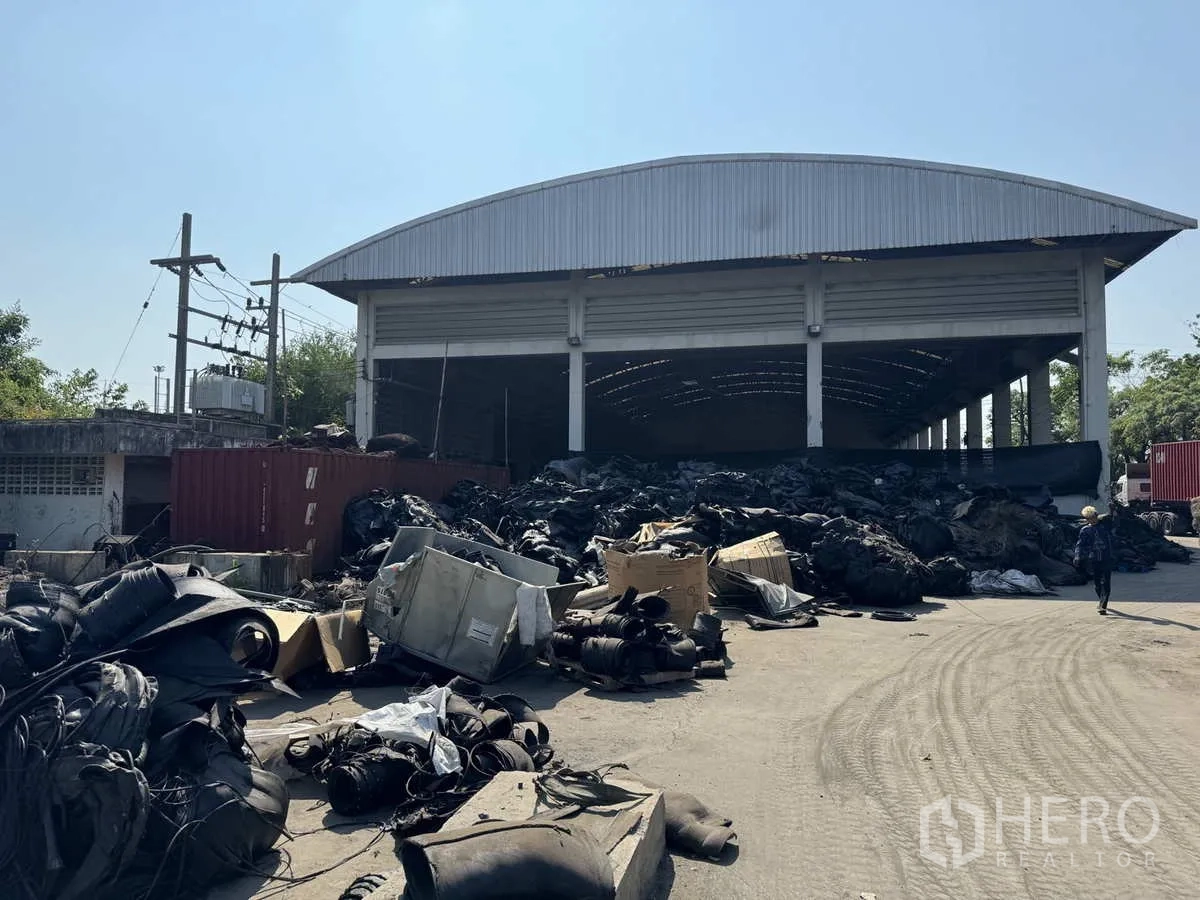 工厂 出租在Lat Lum Kaeo, Pathum Thani - 拱顶仓库正面，前方堆放物料与集装箱