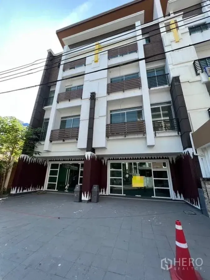 Home Office for sale in Wang Thonglang, Bangkok - Four-storey home office facade with glass storefront and parking area.